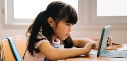 elementary aged student working on a laptop