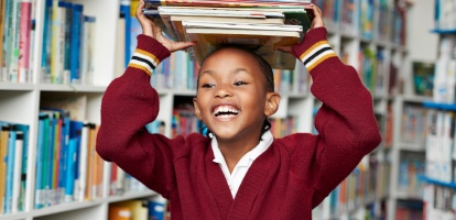 middle school aged child holding books