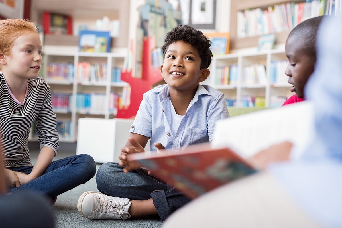 Students sitting on the floor listening to a story