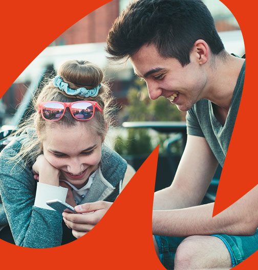 pair of students smiling and looking at a phone