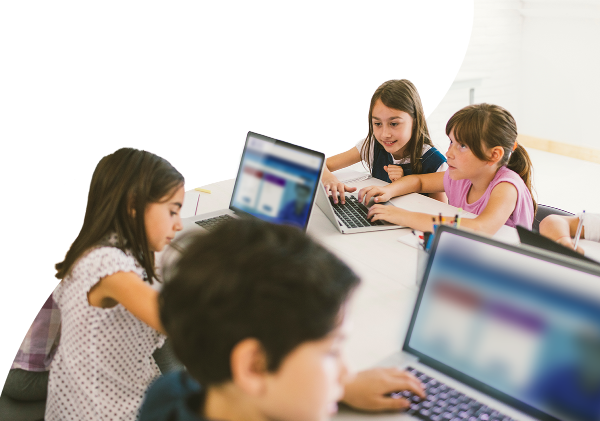 Small group of students working on laptops in a classroom