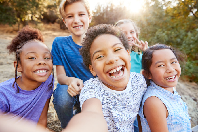 Happy children laughing together outside.