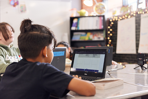 An elementary student working as part of a small group alongside other students during an Imagine Learning EL Education lesson.