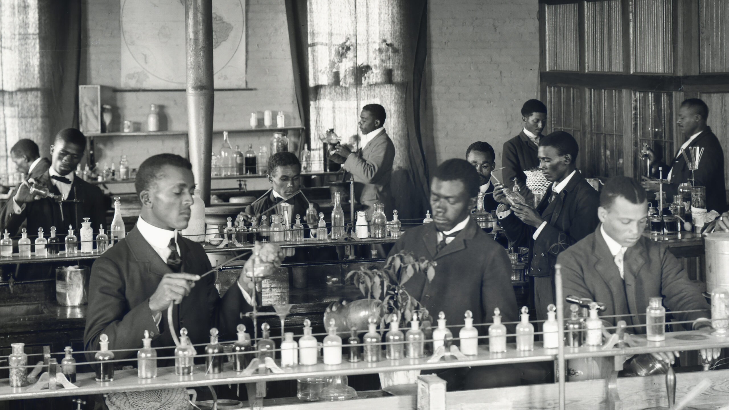 Black chemists in a lab, performing experiments.